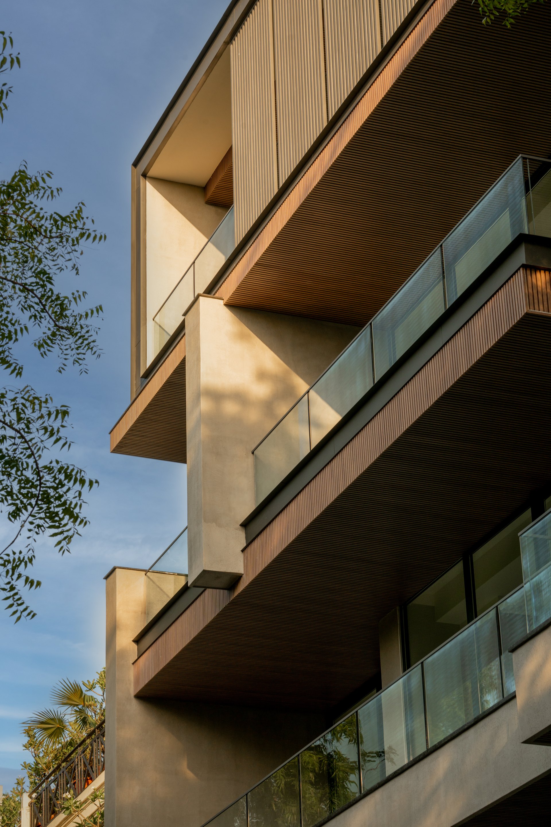 Close architectural view of layered balconies, timber soffits and glass