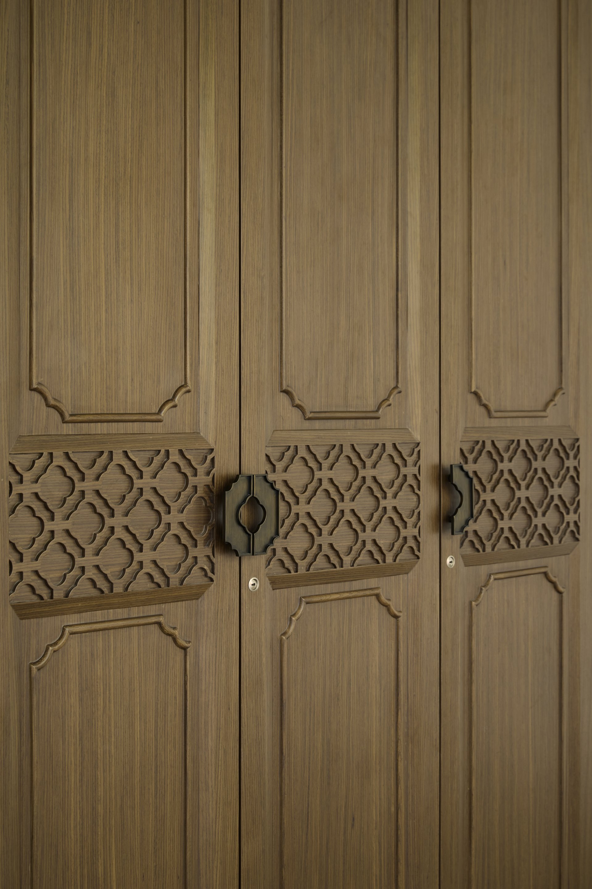 Carved timber doors with precision joinery and custom metal hardware