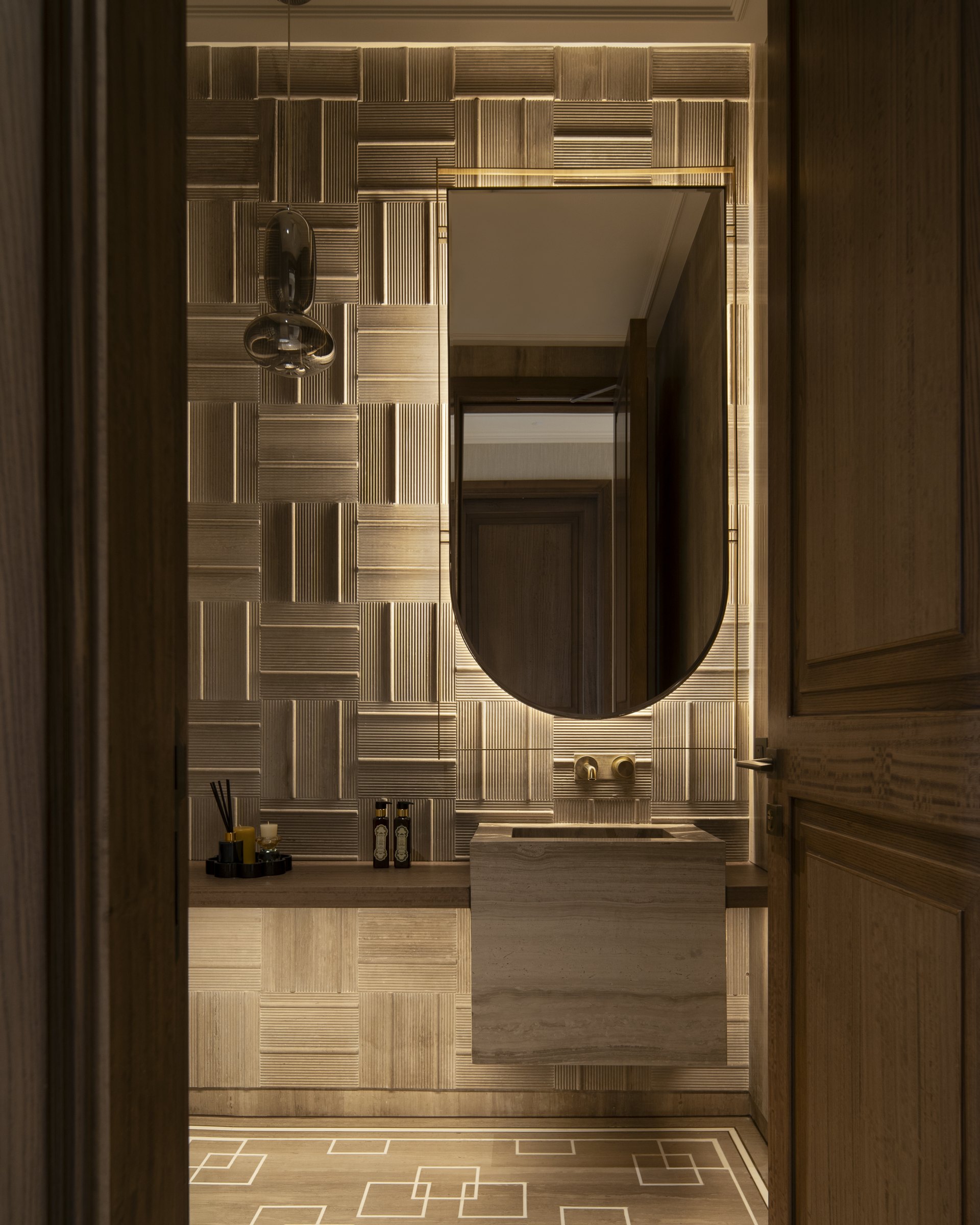 Stone, mirror and timber details composed with integrated lighting